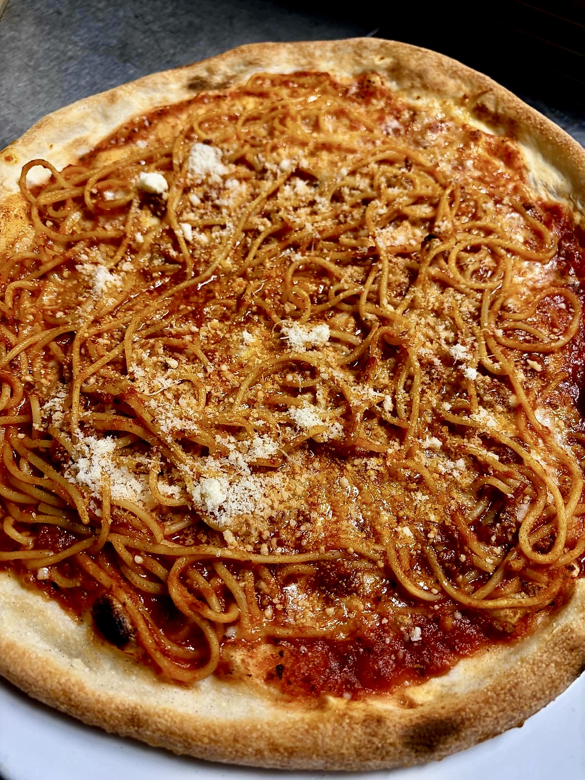 Pizza mit Spaghetti und geriebenem Käse