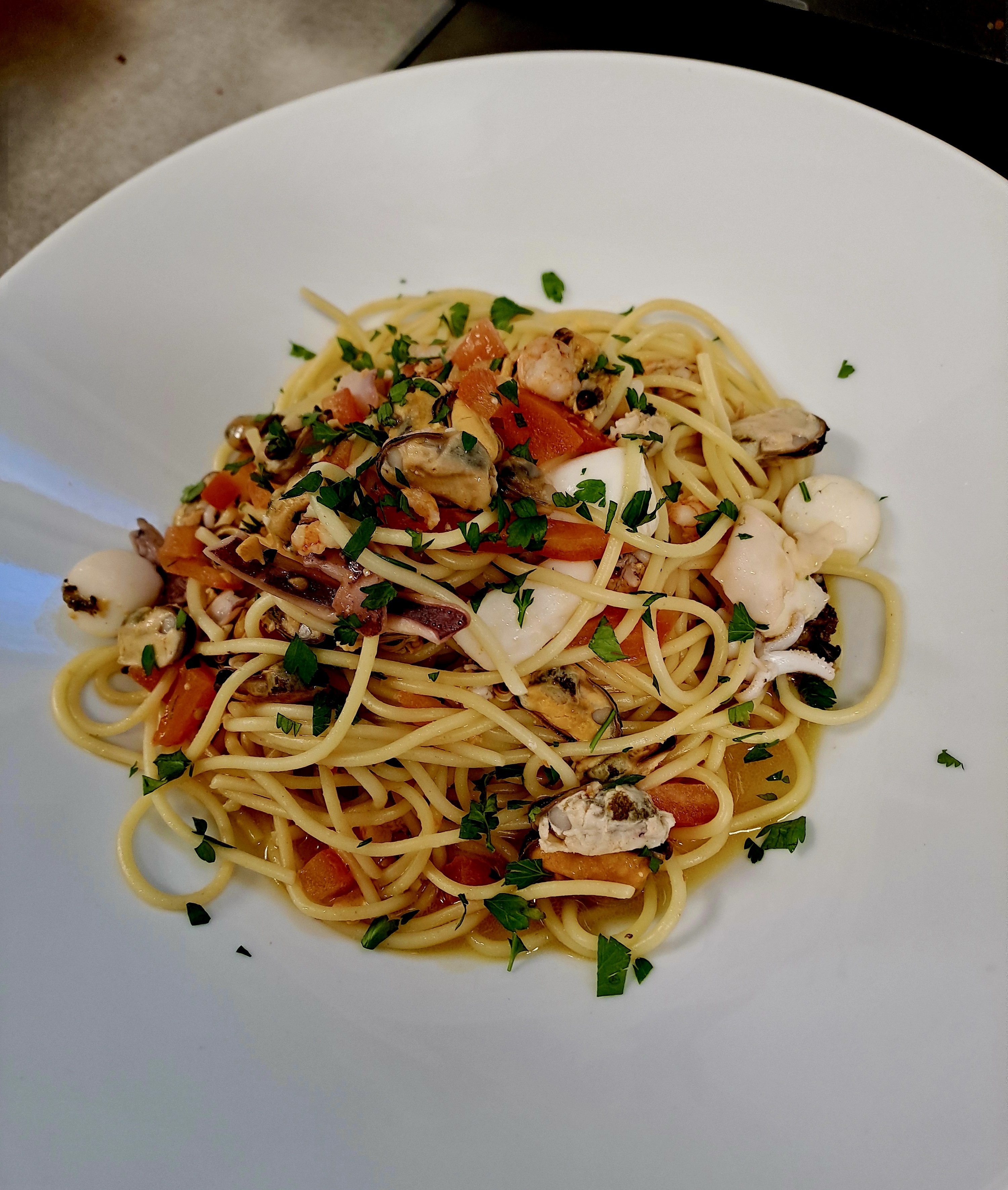 Spaghetti mit Meeresfrüchten, Tomaten und Kräutern aus unserer Küche