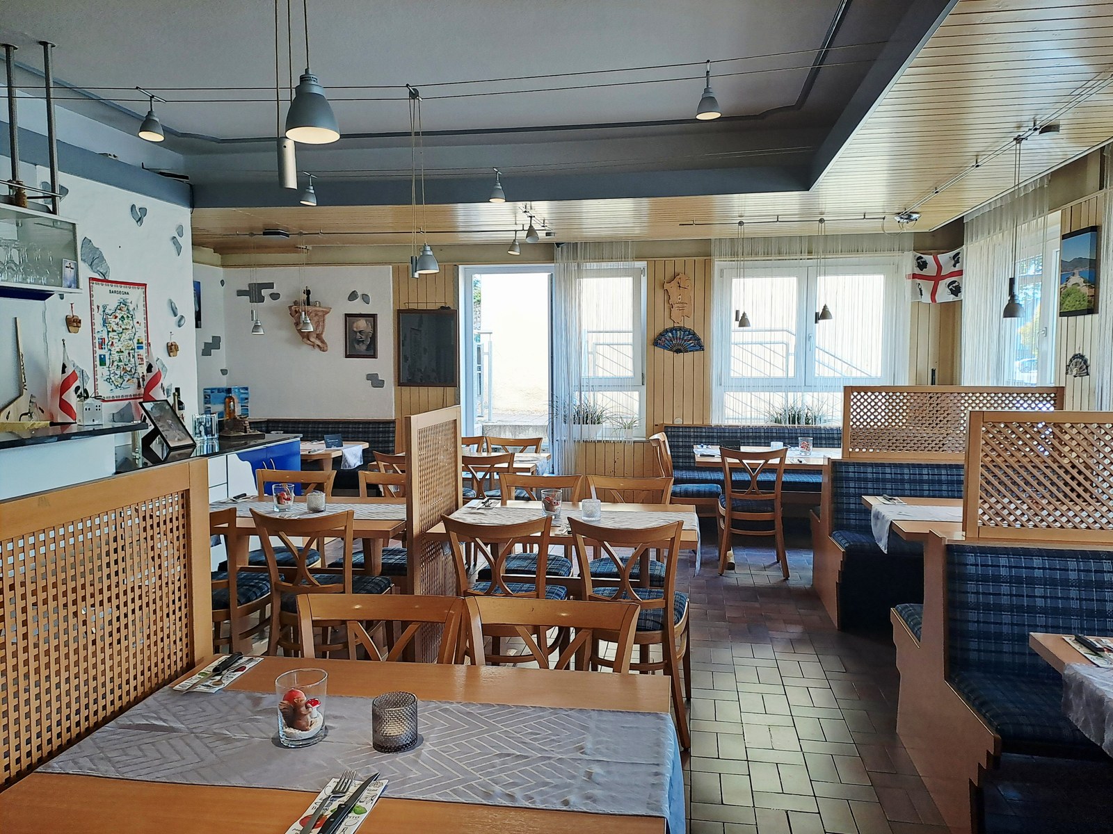 Heller Gastraum der Pizzeria Schwanen mit Holztischen und gemütlichen Sitzplätzen